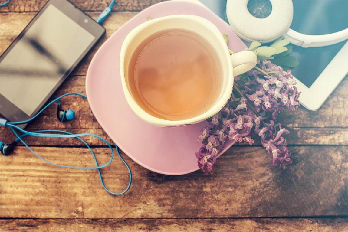 Still life with tea cup and the contents of a work space composed. Different objects on wooden table